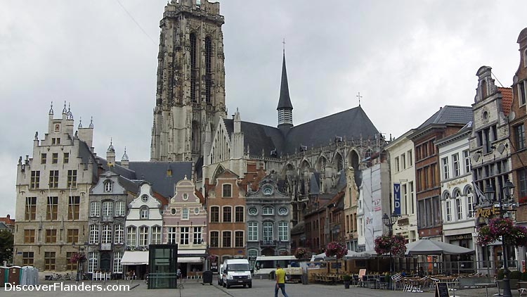 Saint Rumbold's Cathedral, behind houses on the Grand Place in Mechelen.